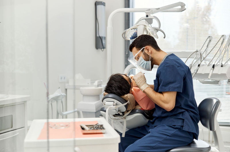 Dentist providing emergency dental treatment to a patient in a modern dental clinic