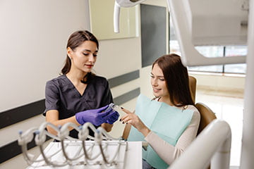 Dentist holding a transparent Invisalign aligner during a clear aligner consultation in Markham.