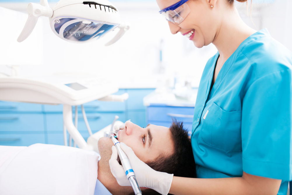Dental hygienist performing routine teeth cleaning at Markham Smile Centre — cleaning costs covered by insurance in Markham